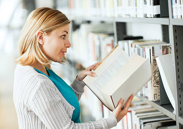 istock Woman taking a book from the library. 174897649