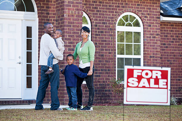 African American family looking at house for sale African American family with two young children (4-5 years) looking at house for sale.  'For Sale' sign is out of focus. for sale sign photos stock pictures, royalty-free photos & images