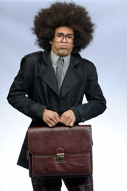 eccentric businessman with big afro hair holding brown leather briefcase blowing cheeks looking at the camera on gray background