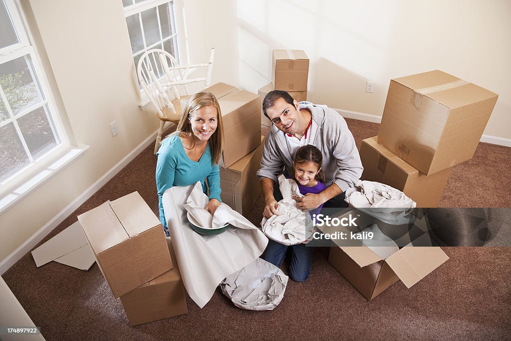 Family packing moving boxes Moving house.  Family with little girl (6 years) packing up dishes in cardboard boxes. 30-39 Years Stock Photo