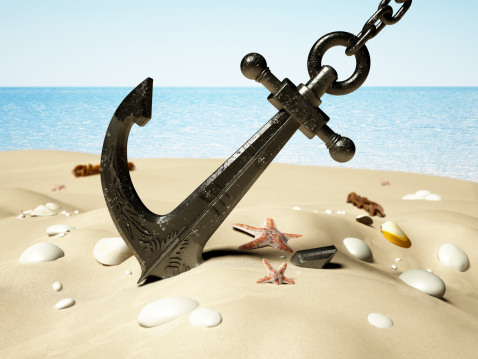 Black anchor with chain stuck on the sand by the seashore.Similar images: