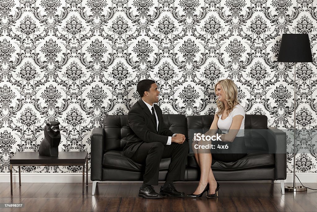 若いカップルは、ソファに座る - �ライオンのロイヤリティフリーストックフォト