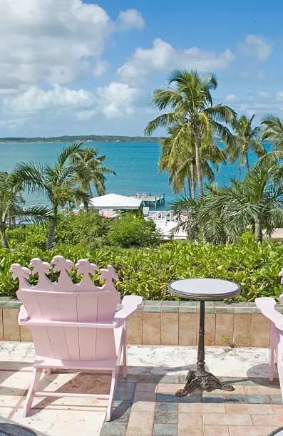 "A view of a pink chair and the ocean on Harbour Island, Bahamas"