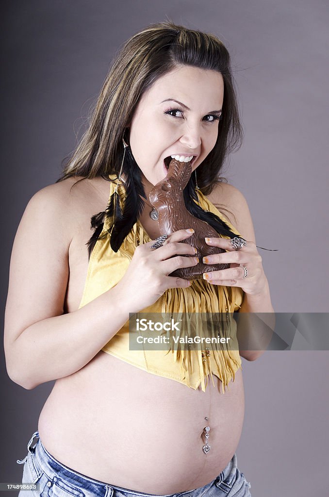 Forte donna incinta holding cioccolato Coniglietto di Pasqua. - Foto stock royalty-free di Cioccolato