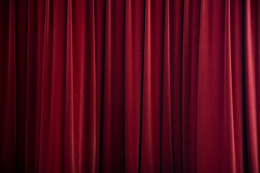 Red curtain on theater or cinema stage open with copy space