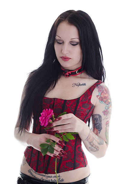 istock Black haired tattooed beauty looking down at rose. 174898818