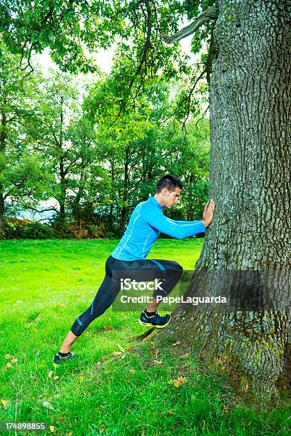 Uomo Lo Stretching I Muscoli Dopo Jogging Allaperto - Fotografie stock e altre immagini di Correre