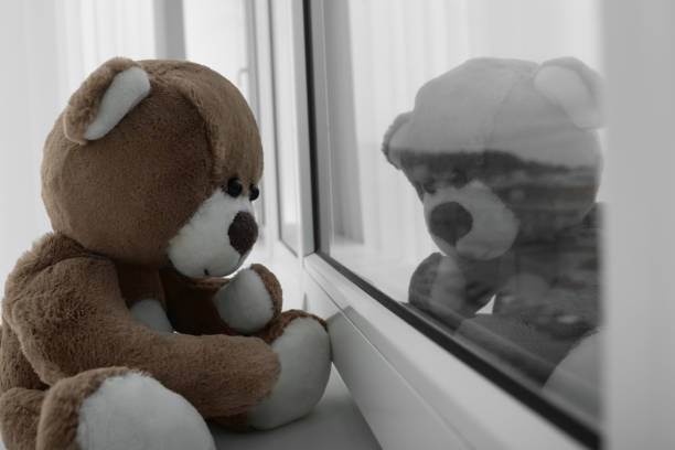 istock Cute lonely teddy bear on windowsill indoors, closeup. Space for text 1748989506