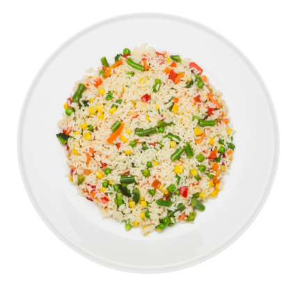 Plate with fried rice with vegetables isolated on white