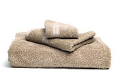 A pile of brown bath towels on a white background