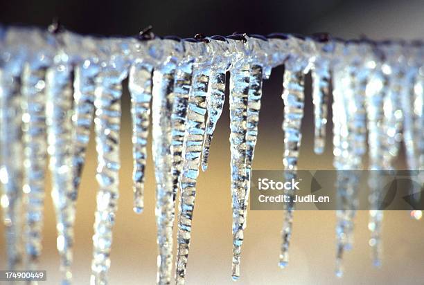 Foto de Pingentes De Gelo De Frozen Em Uma Cerca De Malha De Arame e mais fotos de stock de Fileira