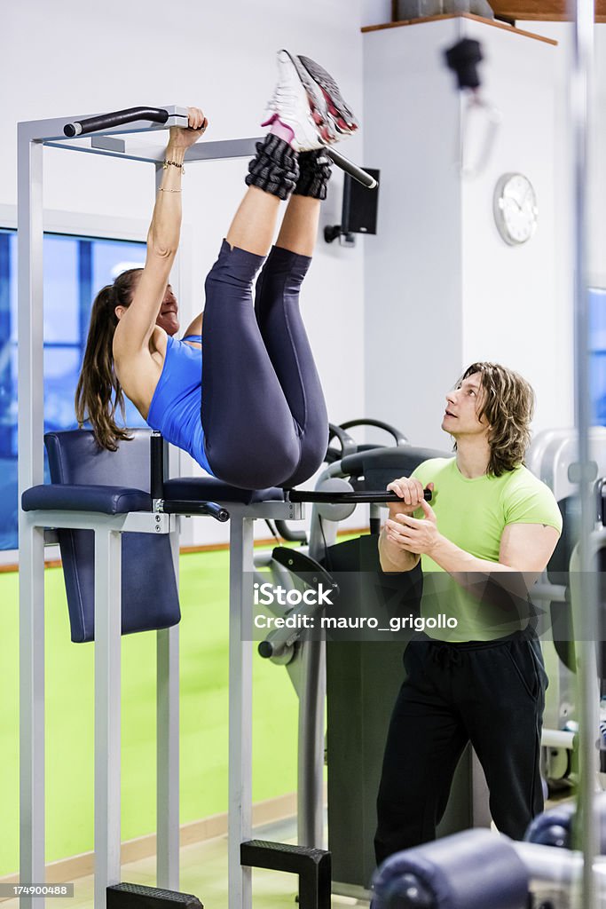 Donna facendo crunch esercizi con personal trainer - Foto stock royalty-free di Abbigliamento casual