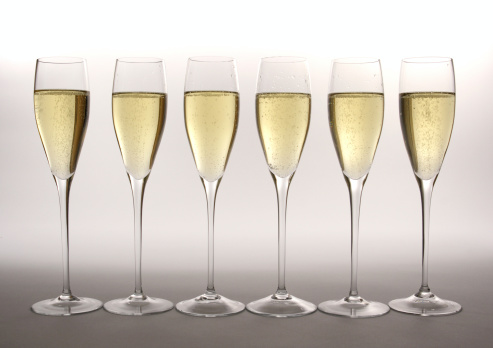 Subject: A line of flutes with Champagne against a soft white background