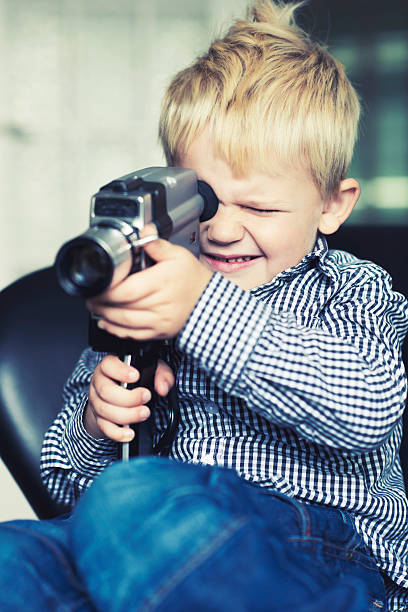 istock Little boy makes a video with an old retro camera 174900635