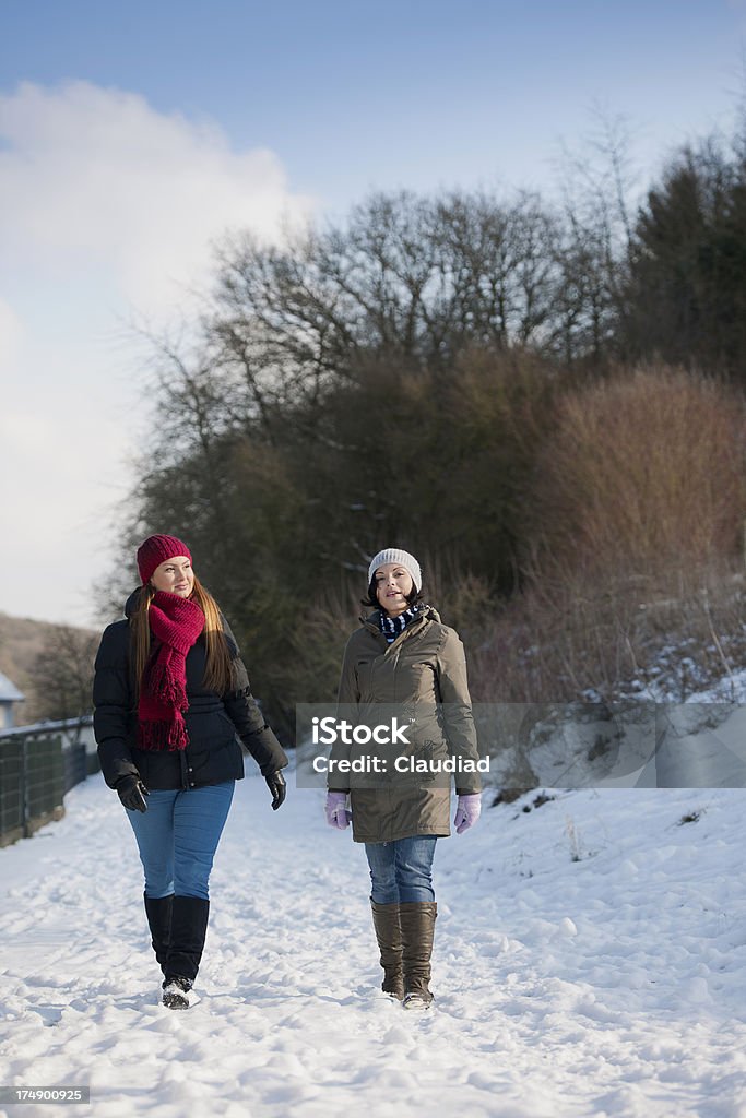 Dos mujeres caminando en la nieve - Foto de stock de 25-29 años libre de derechos