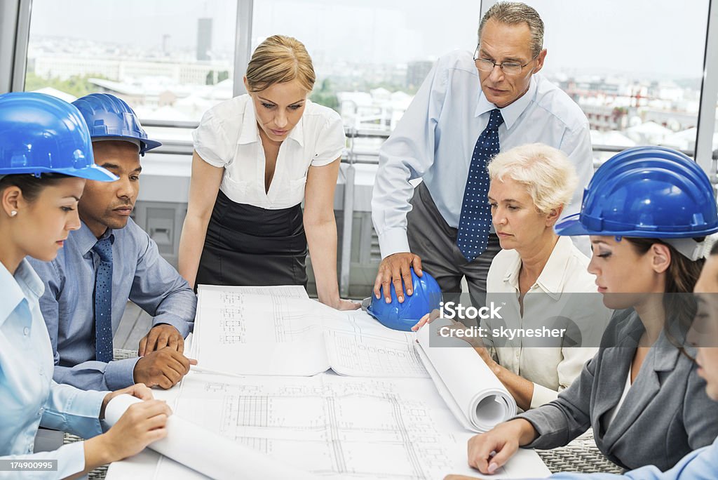 Gruppo di architetti che lavorano su un progetto. - Foto stock royalty-free di Abbigliamento da lavoro