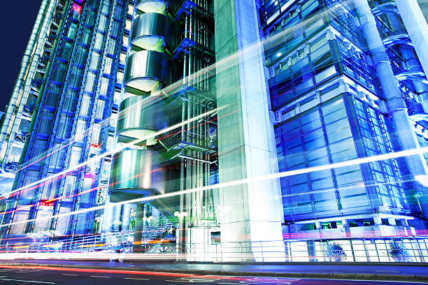 Illuminated Futuristic Architecture and Car Light Trails at Night, London