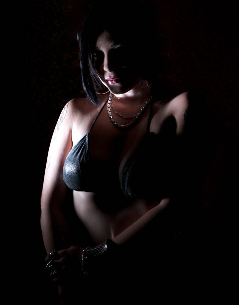 istock Dramatic Lighting Female In Bikini Top Against Black Backgrount 174901259
