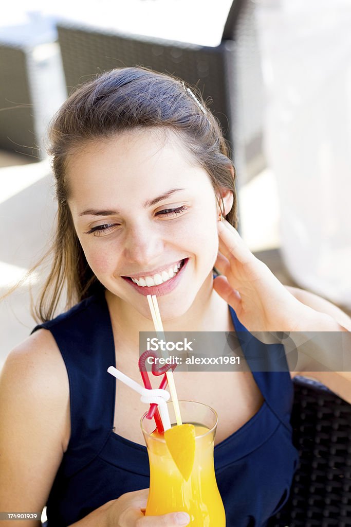 Красивая молодая женщина с апельсиновый сок, улыбающихся в Летнее кафе - Стоковые фото Апельсин роялти-фри
