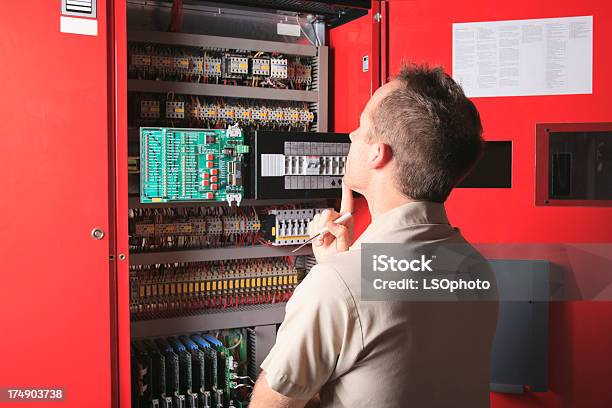 Repairman Elevator Thinking Stock Photo - Download Image Now - Control Panel, Indoors, Maintenance Engineer