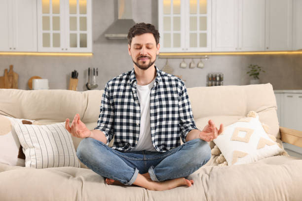 istock Man meditating on sofa at home. Harmony and zen 1749040648