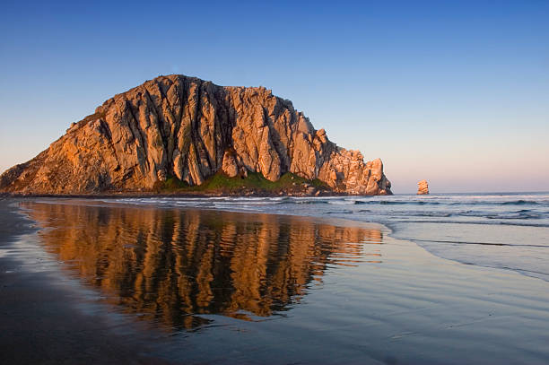Image of Morro Rock and its reflection in water Sunrise on Morro Rock in CA morro castle havana stock pictures, royalty-free photos & images