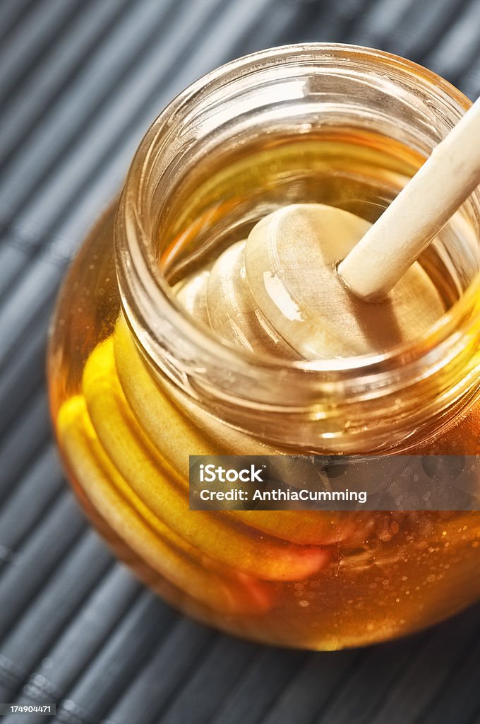 Pote de oro pure de miel con una miel drizzler de madera - Foto de stock de Miel libre de derechos