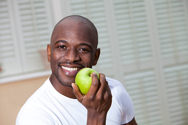 istock Young African man eating a juicy green apple 174904513