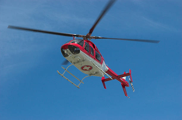 Closeup of flying red helicopter in contrast with blue sky stock photo