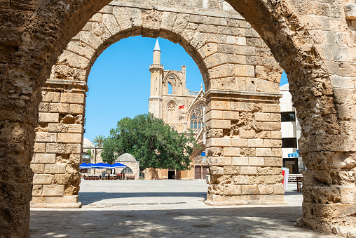 Famagusta is a city on the east coast of Cyprus. Saint Nicholas's Cathedral can be seen through the ruined arches of the royal palace.