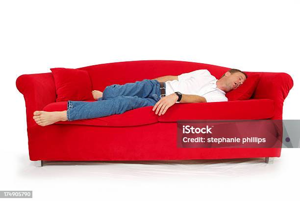 Uomo Che Dorme Su Un Divano Rosso Con Sfondo Bianco - Fotografie stock e altre immagini di Dormire