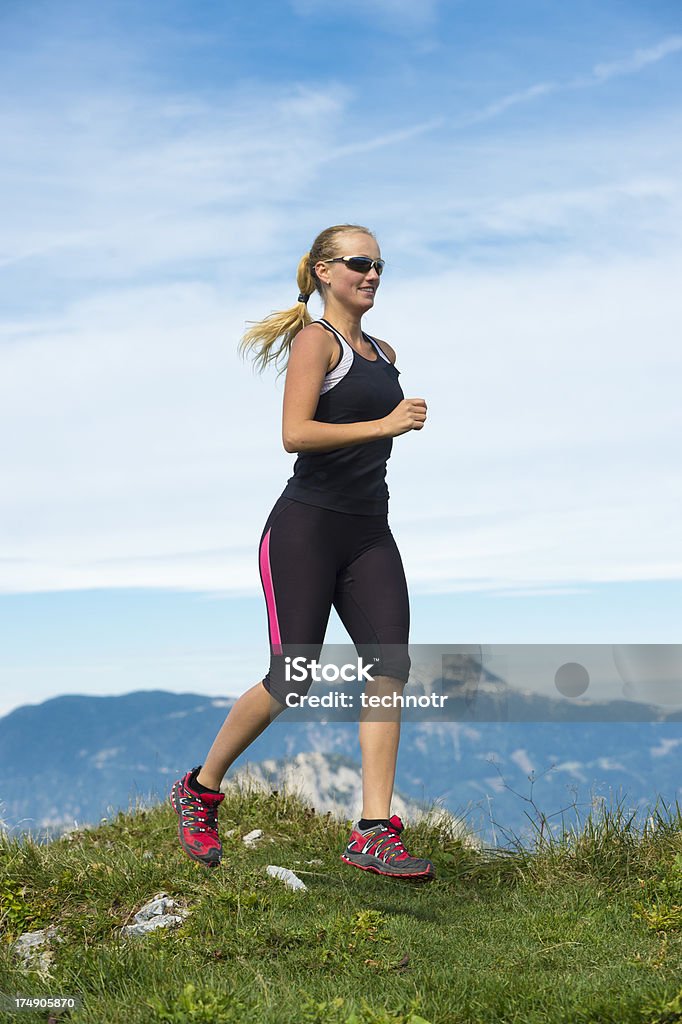 Belle jeune femme en train de courir dans les montagnes - Photo de 20-24 ans libre de droits