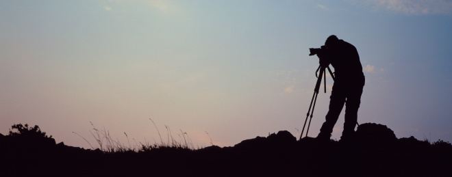 A photographer at the top of a mountain is silhouetted against a sunrise sky Other Related Pictures in my portfolio: