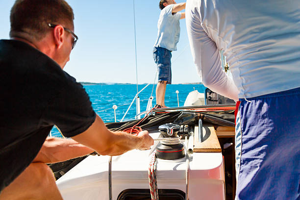 istock Sailing crew on sailboat settng up main sail 174906195