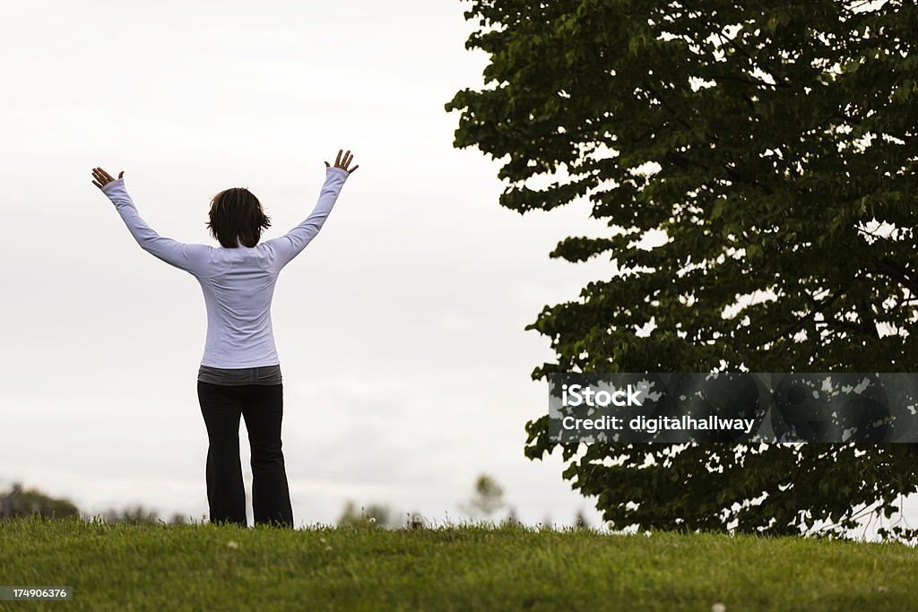 Mature Woman Worshipping outdoors Mature woman raising hands in worship outdoors 45-49 Years Stock Photo