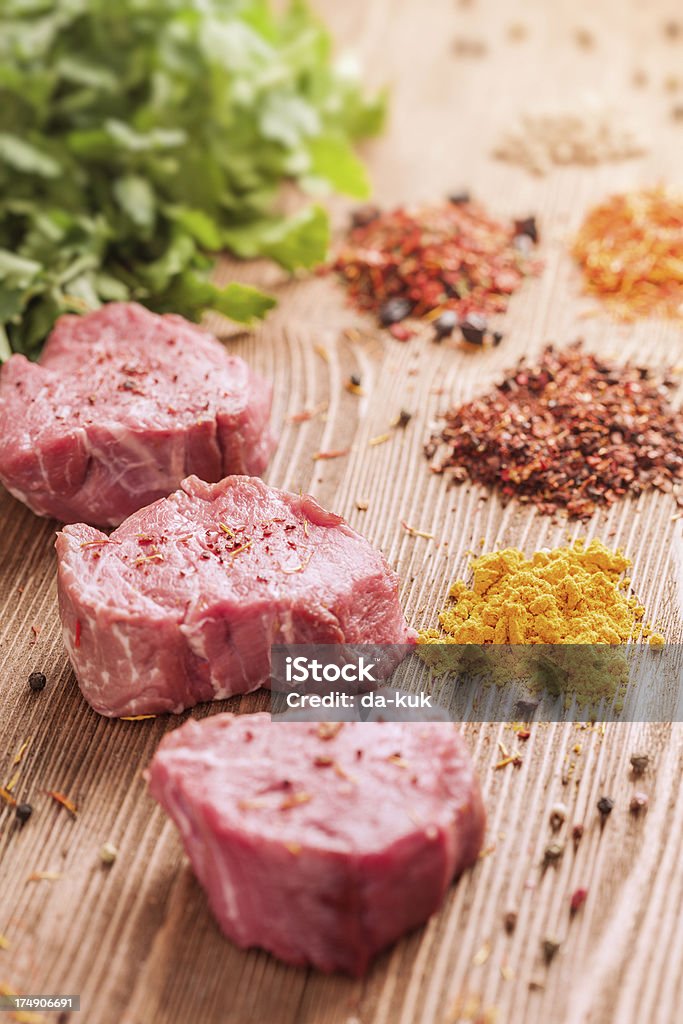 Meat on wooden table Fresh meat lying on wooden table with spices Beef Stock Photo