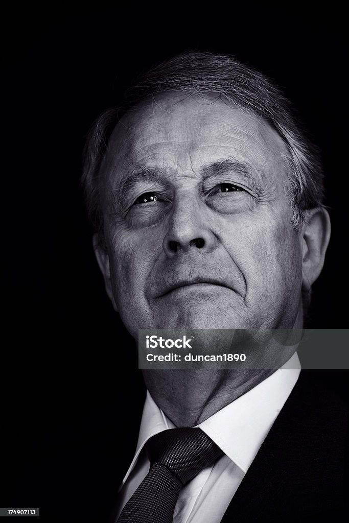 Business Leader A senior businessman against a black background. Black And White Stock Photo