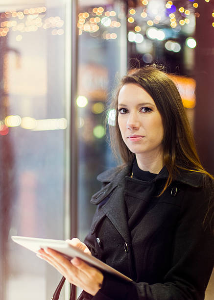 istock Young woman using digital tablet in front of store window 174907834