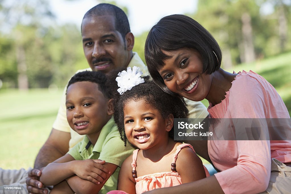Семья с двумя детьми, сидящая на открытом воздухе - Стоковые фото 30-39 лет роялти-фри