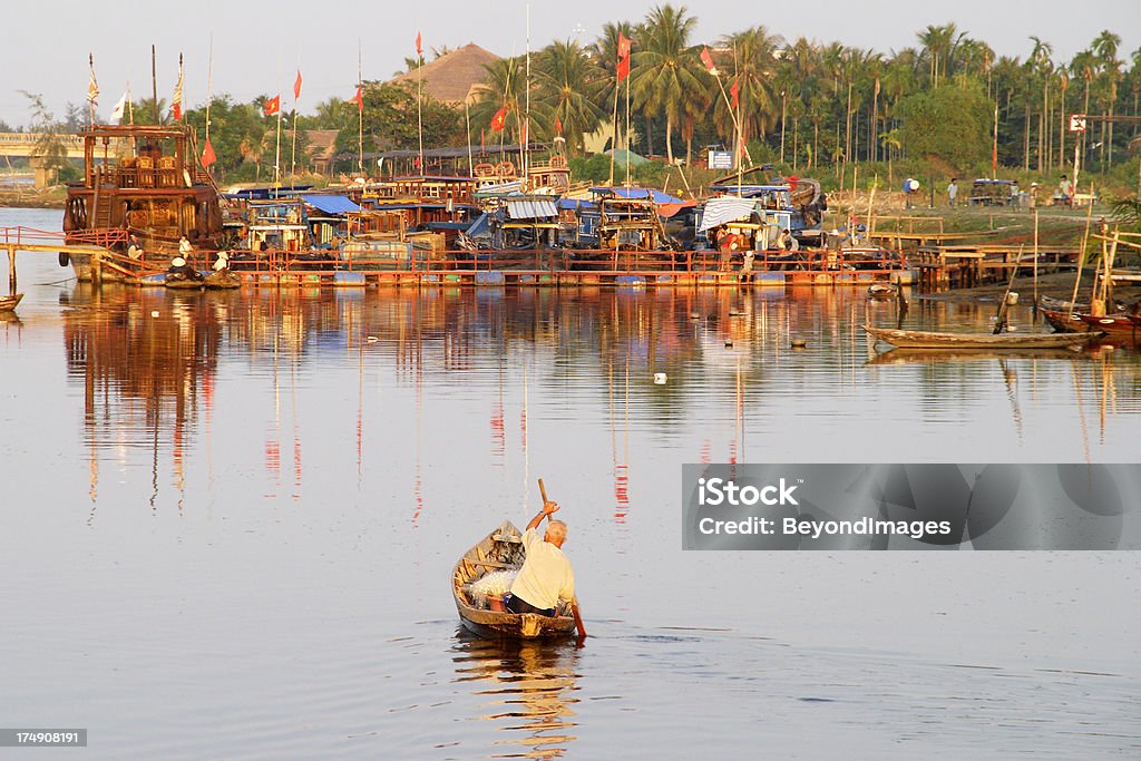 Idosos boatman remo no Hoi An rio no pôr-do-sol - Foto de stock de Adulto royalty-free