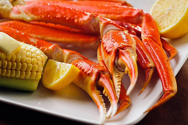 Snow Crab Legs Snow crab leg plate with corn on the cob and lemon.  Please see my portfolio for other food related images. snow crab photos stock pictures, royalty-free photos & images