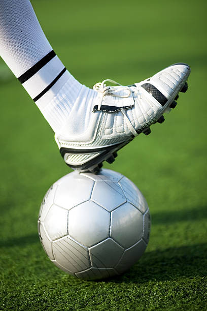 anti-racist skinhead wearing boots and showing his love for football (typical english hooligan). outdoor photo, daylight only. high contrast. selected focus on shoe laces.