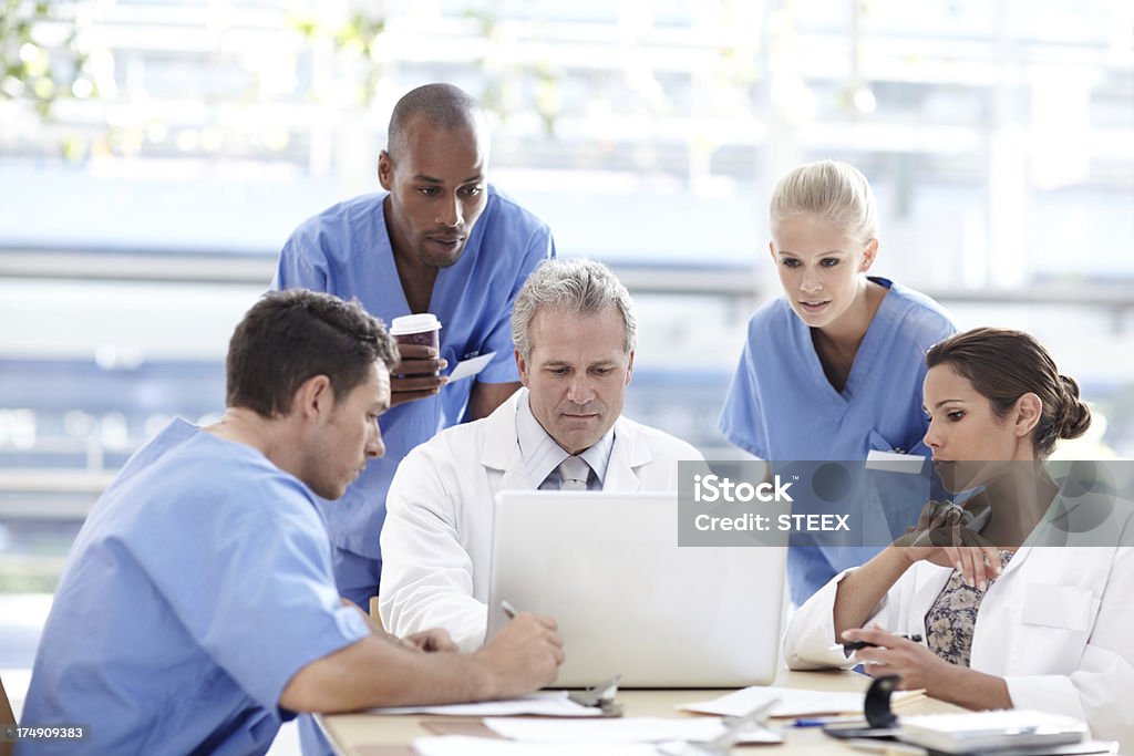 Dedicated team of healthcare professionals A team of medical professionals working around a laptop Adult Stock Photo