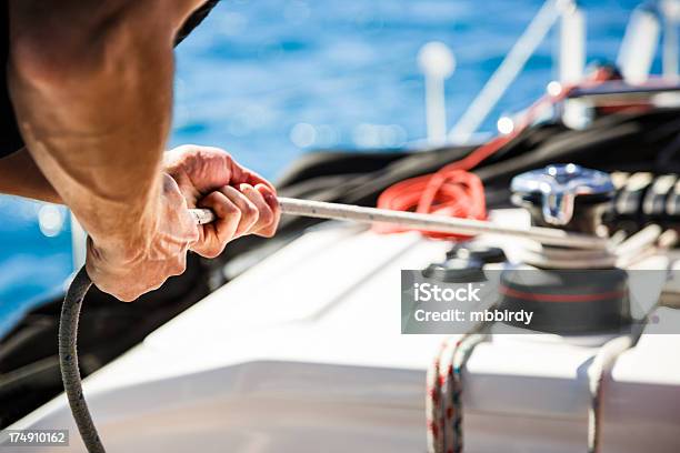 Sailing Crew Member Pulling Rope On Sailboat Stock Photo - Download Image Now - Crew, Sailing, Sailboat