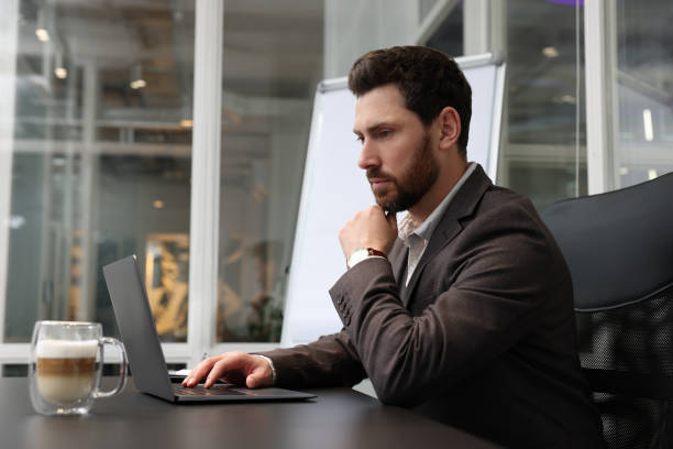 istock Man working on laptop at black desk in office 1749102781