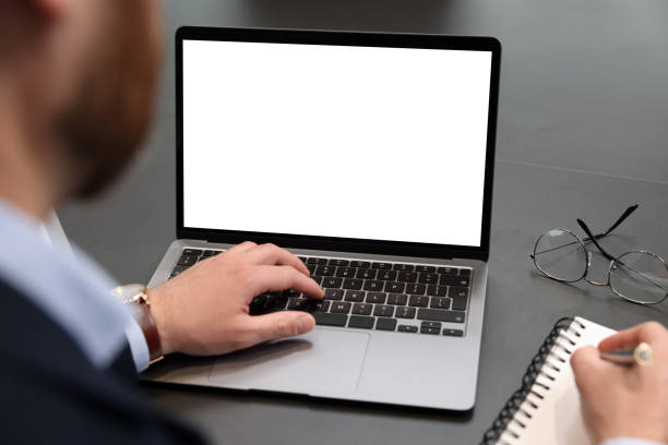 istock Man writing notes while working on laptop at black desk in office, closeup 1749102806
