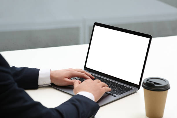 istock Man working on laptop at white desk in office, closeup 1749103336