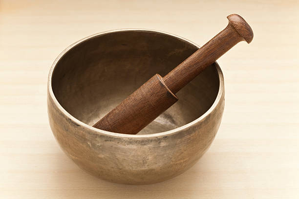 A Tibetan singing bowl, used for sound healing and crystal cleansing. Focus is sharp on the handle of the wooden mallet. This image is unsharpened.