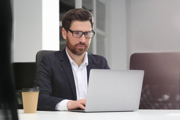 istock Man working on laptop at white desk in office 1749103940