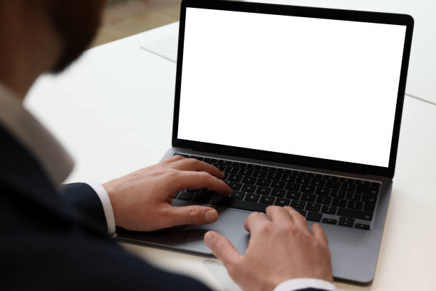 istock Man working on laptop at white desk in office, closeup 1749104564